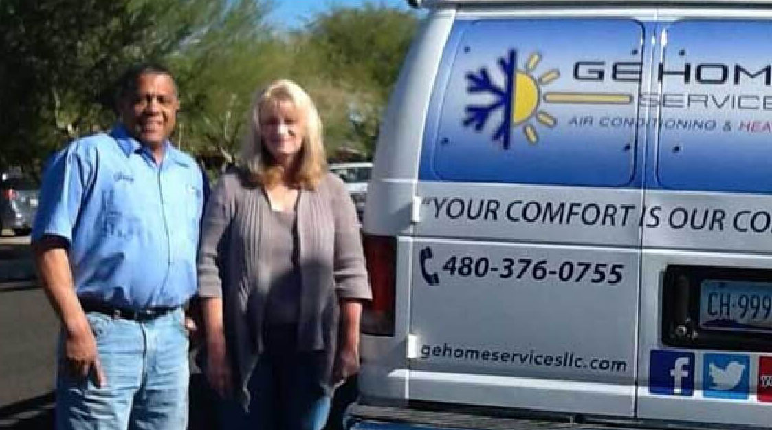 A man and woman standing in front of a van.